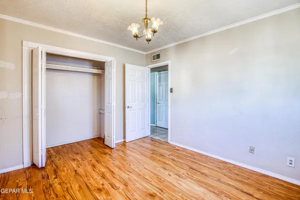 a bedroom with a bed and a chandelier fan