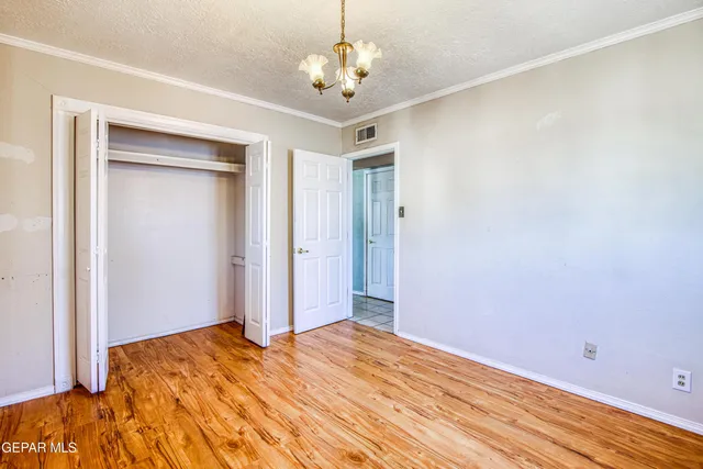 a bedroom with a bed and a chandelier fan