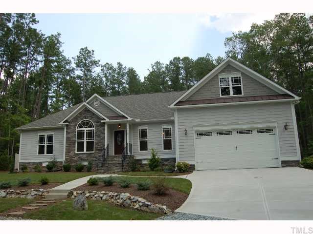 6912 Johnson Mill Road Bahama, NC 27503 - Photo 1 of 12 a front view of a house with a yard and garage