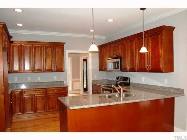 6912 Johnson Mill Road Bahama, NC 27503 - Photo 3 of 12 a kitchen with kitchen island granite countertop a sink a counter top space and cabinets