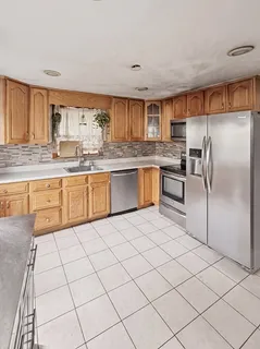 a kitchen with stainless steel appliances granite countertop a refrigerator sink and cabinets