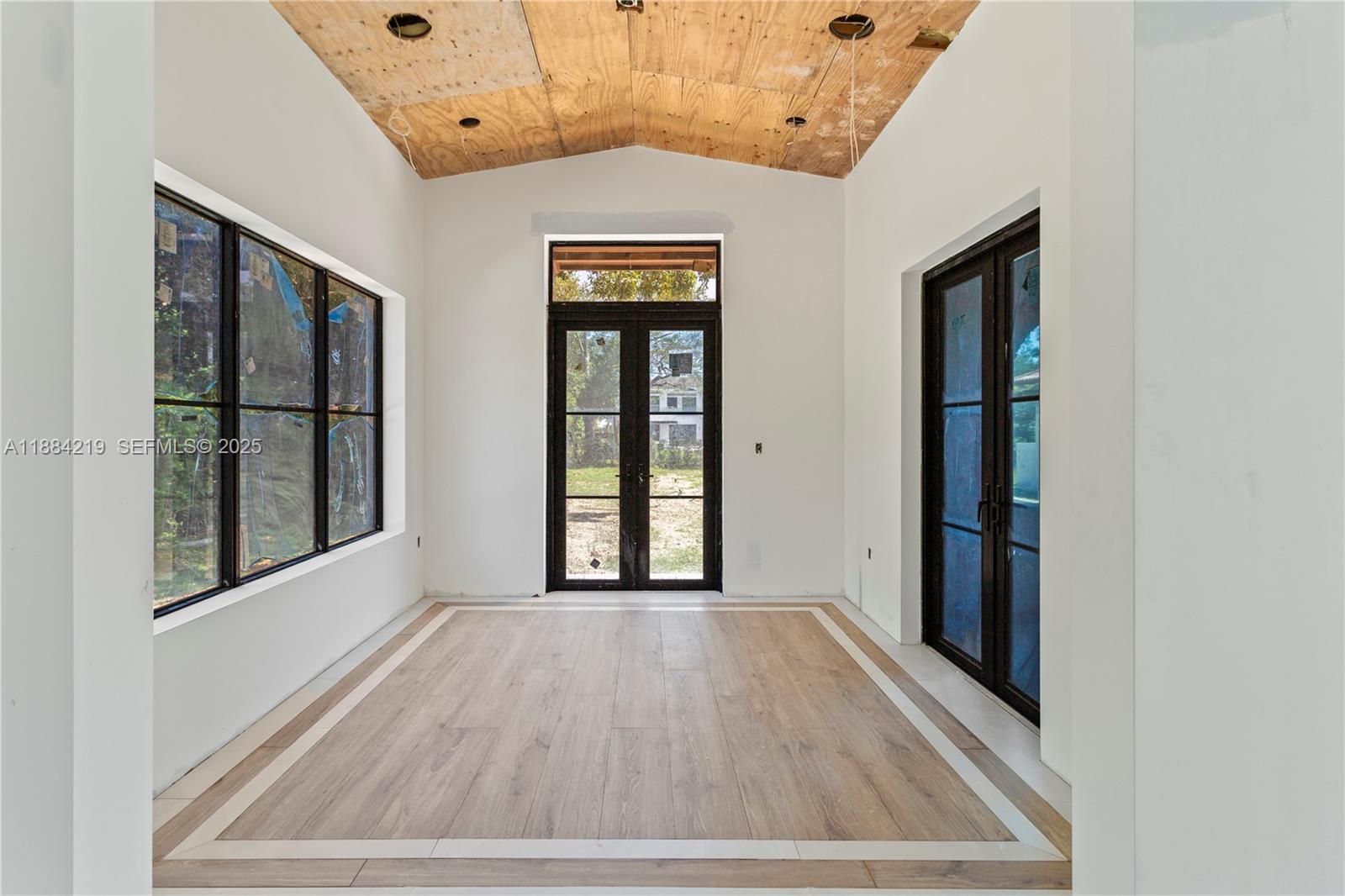 6460 Southwest 94th Street Pinecrest, FL 33156 - Photo 17 of 43 wooden floor in an empty room with a window