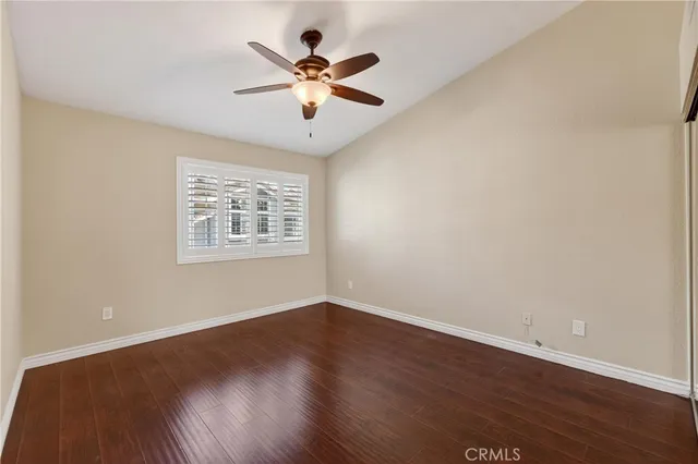 a view of a big room with wooden floor and windows