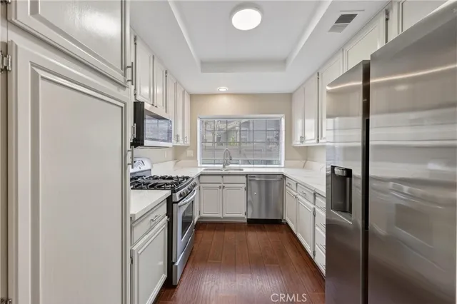 a kitchen with a sink a stove top oven and refrigerator