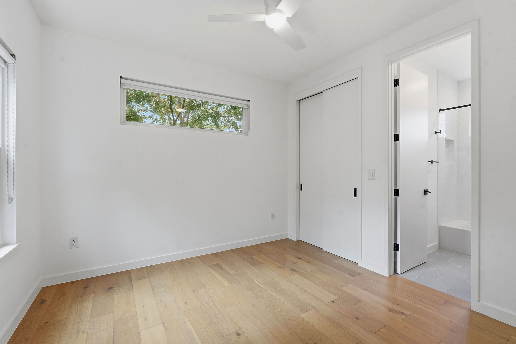 1707 Deloney Street, Unit 2 Austin, TX 78721 - Photo 19 of 26 Hardwood floors and a ceiling fan create a serene and inviting atmosphere in this bedroom.
