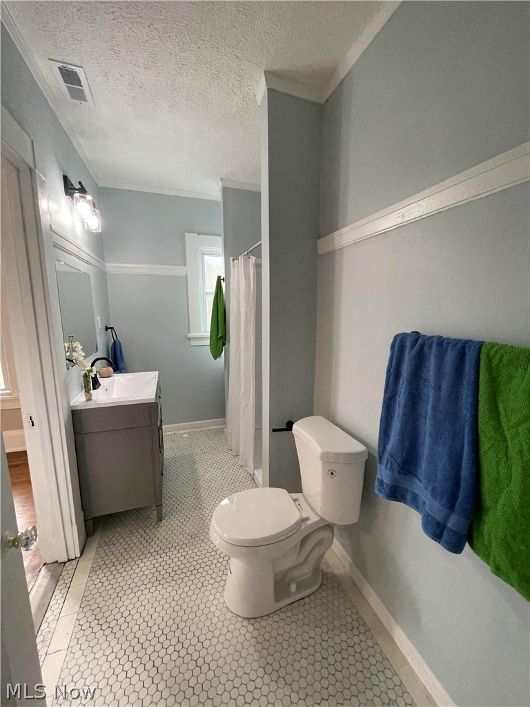 1843 Farmington Road Cleveland, OH 44112 - Photo 23 of 48 Bathroom featuring vanity, crown molding, toilet, a textured ceiling, and tile original patterned flooring