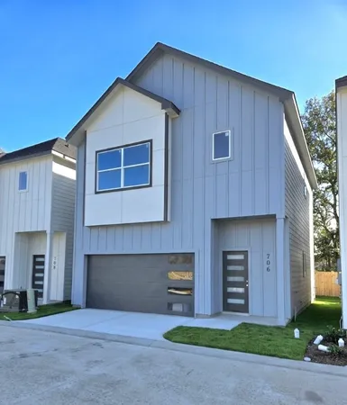 a front view of a house with a garden and garage
