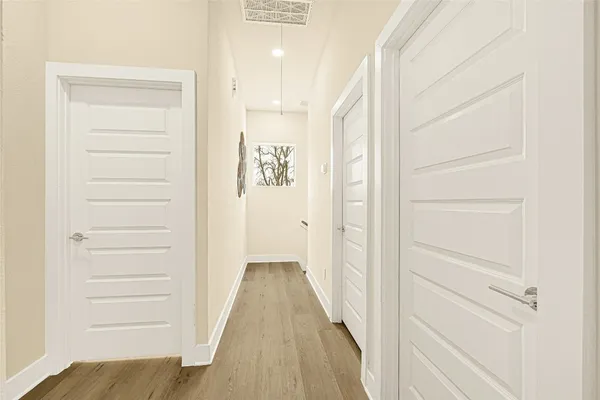 a view of a hallway with wooden floor and closet