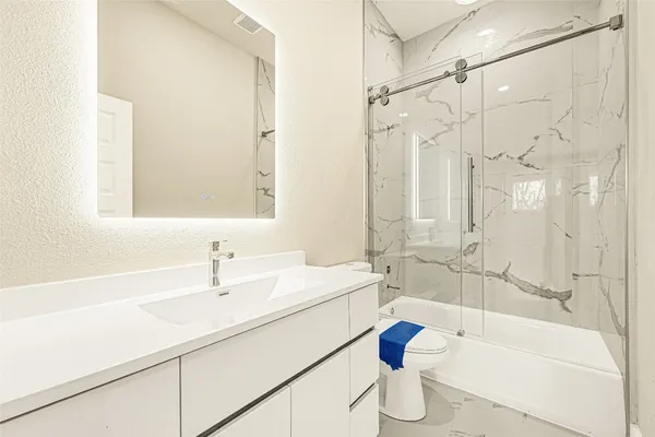 a bathroom with a sink mirror toilet and bathtub