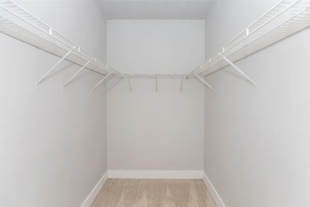 a view of an empty room and chandelier fan