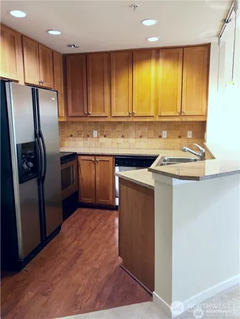 a kitchen with stainless steel appliances granite countertop a sink stove and refrigerator