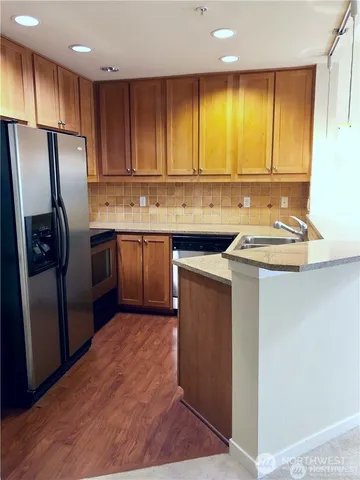 a kitchen with stainless steel appliances granite countertop a sink stove and refrigerator