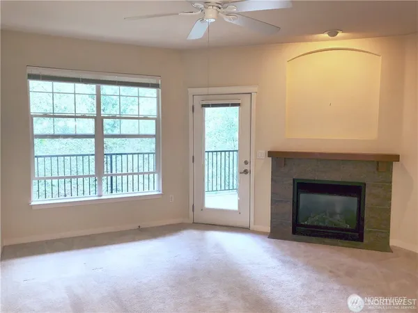 an empty room with windows and fireplace