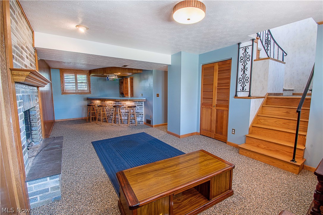 1272 Stewart Road Salem, OH 44460 - Photo 22 of 30 Recreation room that features a beautiful gas fireplace, Nature Stone floor, and a wet bar perfect to enjoy with family and friends.