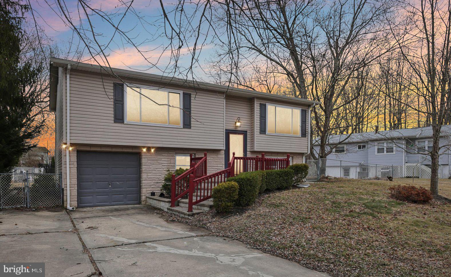 a view of a house with a yard and large tree