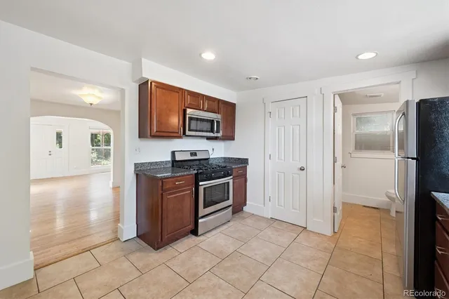a kitchen with stainless steel appliances granite countertop a refrigerator and a stove top oven