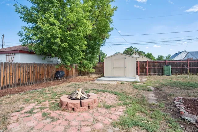a view of a backyard with table and chairs and wooden fence