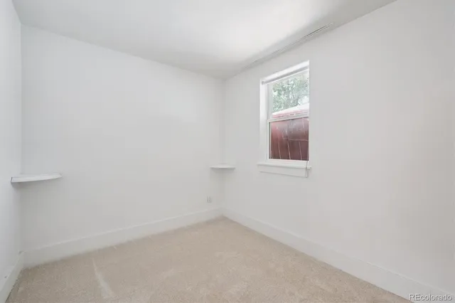 a view of an empty room with closet and window