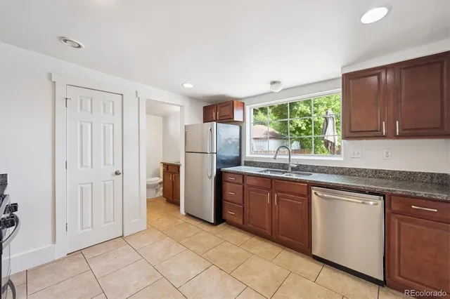 a kitchen with stainless steel appliances granite countertop a refrigerator and a sink
