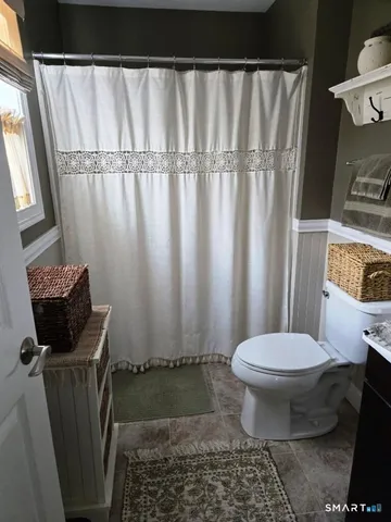 a bathroom with a toilet and a shower