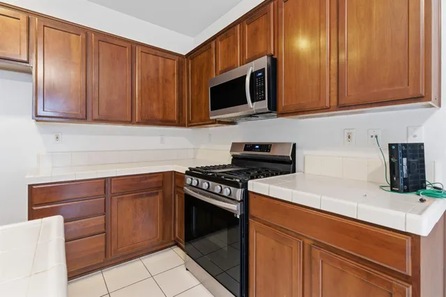 a kitchen with stainless steel appliances granite countertop a sink and a refrigerator