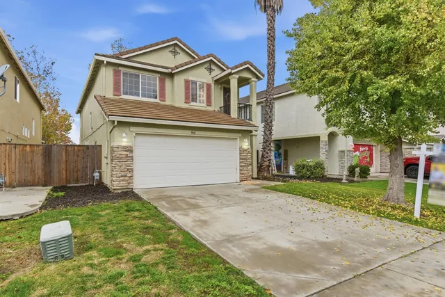 a front view of a house with a yard and garage