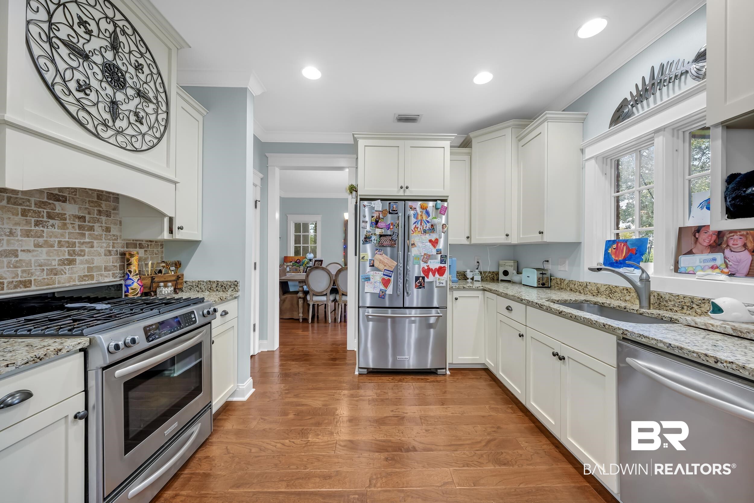 7 Bienville Avenue Mobile, AL 36606 - Photo 15 of 32 Kitchen with appliances with stainless steel finishes, ornamental molding, light wood-style flooring, white cabinetry, and recessed lighting