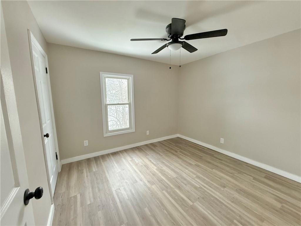 570 High Street Conneaut Lake, PA 16316 - Photo 14 of 26 a view of empty room with wooden floor and fan