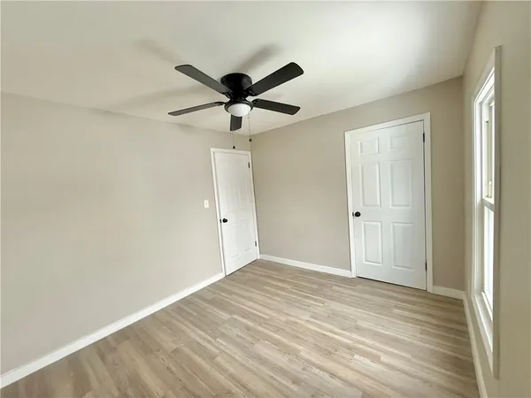 a view of a big room with wooden floor and a ceiling fan