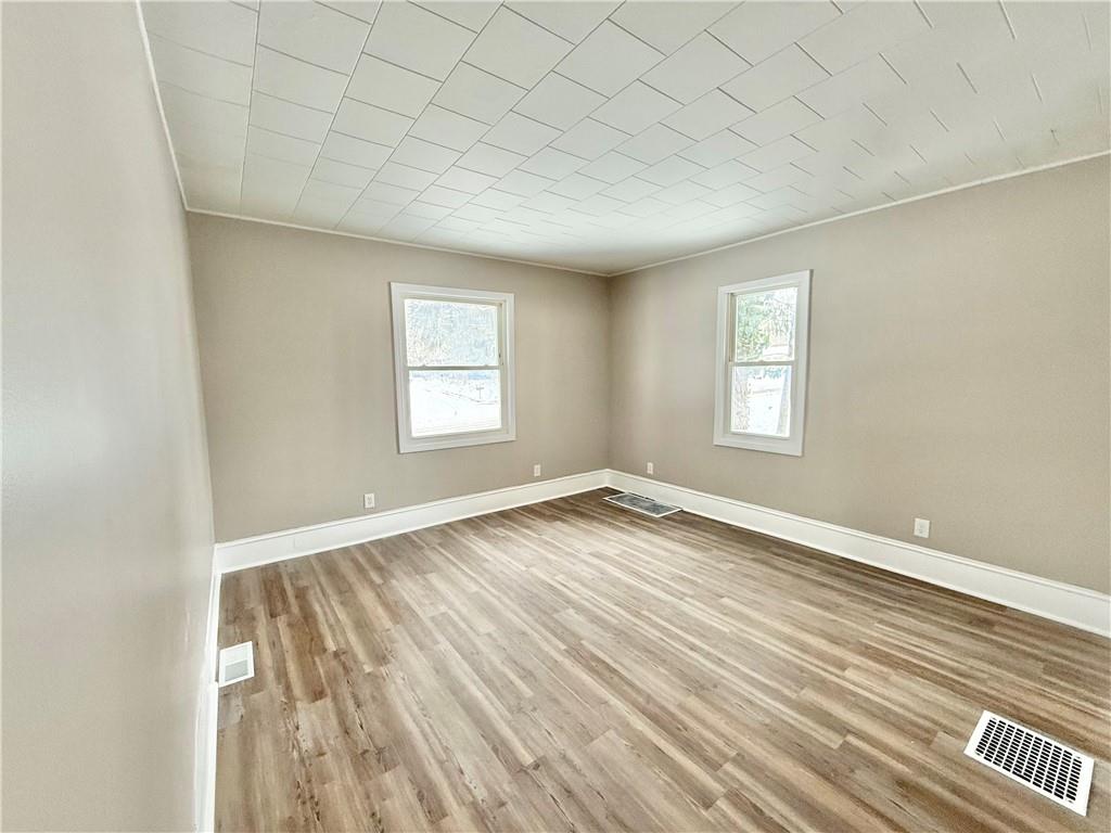 570 High Street Conneaut Lake, PA 16316 - Photo 7 of 26 an empty room with wooden floor and windows