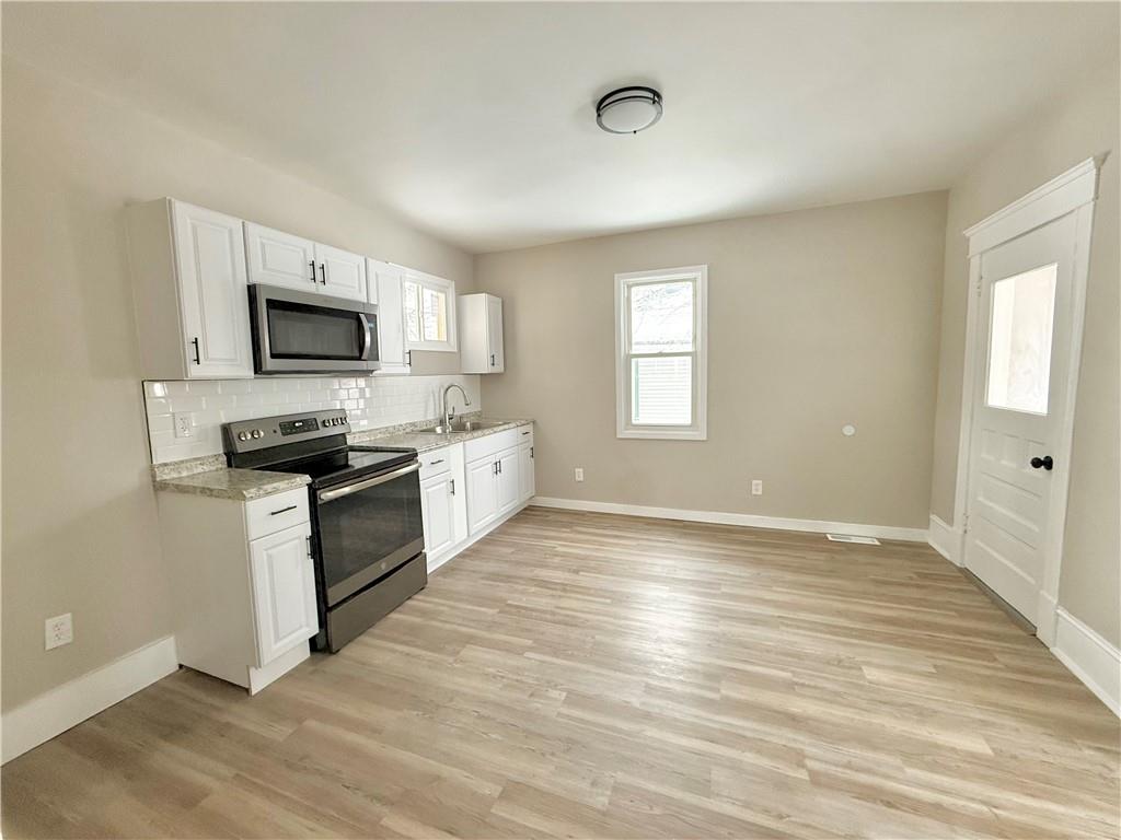 570 High Street Conneaut Lake, PA 16316 - Photo 8 of 26 a kitchen with granite countertop a stove top oven a sink dishwasher a refrigerator and a microwave oven with wooden floor