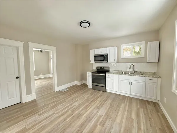 a kitchen with granite countertop white cabinets and white appliances