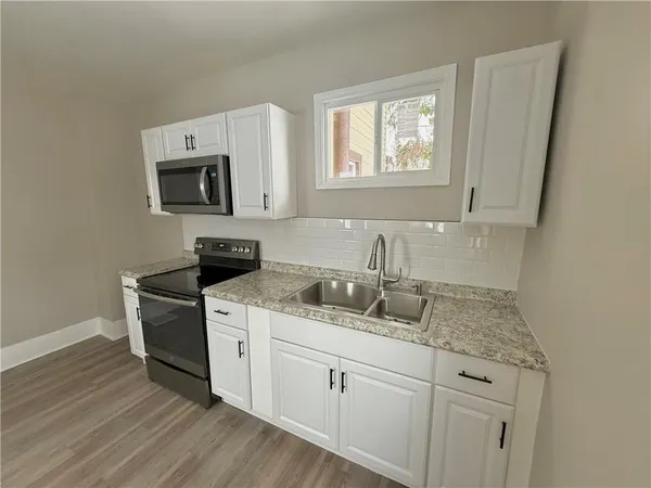 a kitchen with granite countertop white cabinets and white appliances