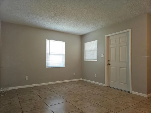 a view of an empty room with window and closet area