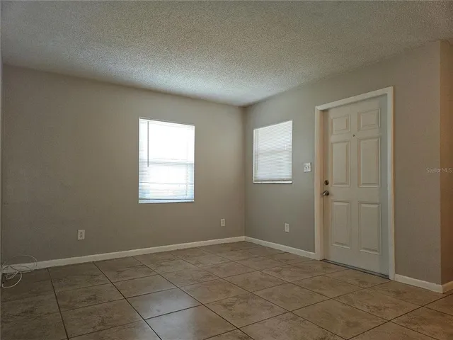 a view of an empty room with window and closet area