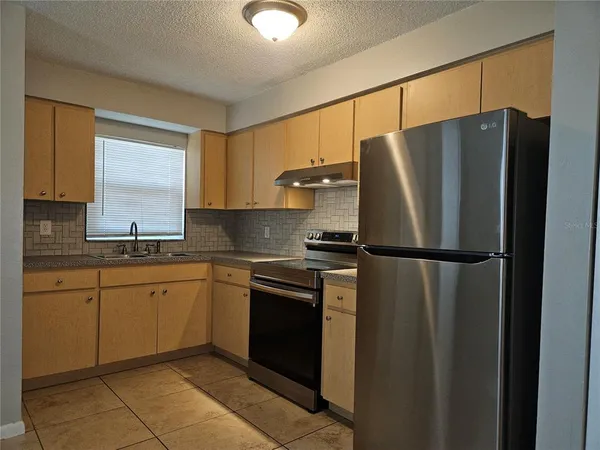 a kitchen with stainless steel appliances granite countertop a refrigerator and a sink