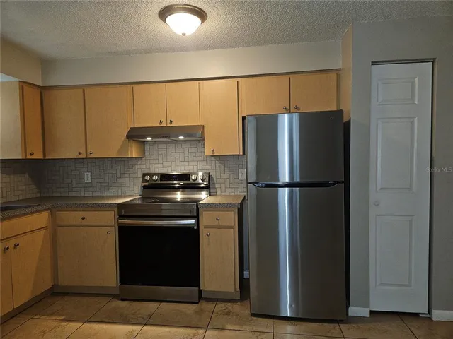 a kitchen with a refrigerator and a sink