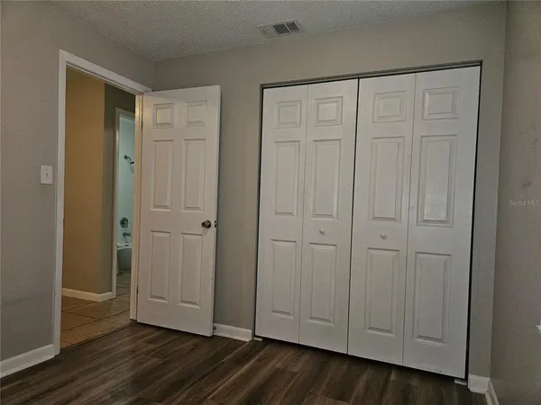 a view of empty room with wooden floor