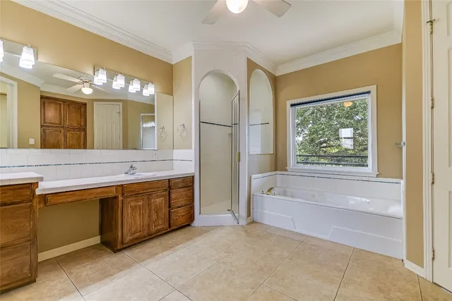 a spacious bathroom with a tub sink and mirror