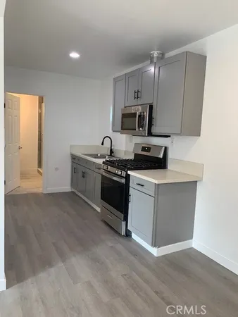 a kitchen with a sink a microwave and cabinets