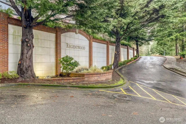 a view of a house with a yard and large tree
