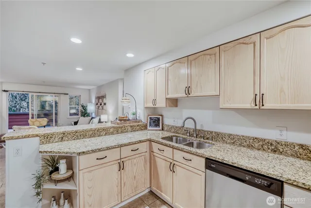 a kitchen with granite countertop stainless steel appliances sink and cabinets