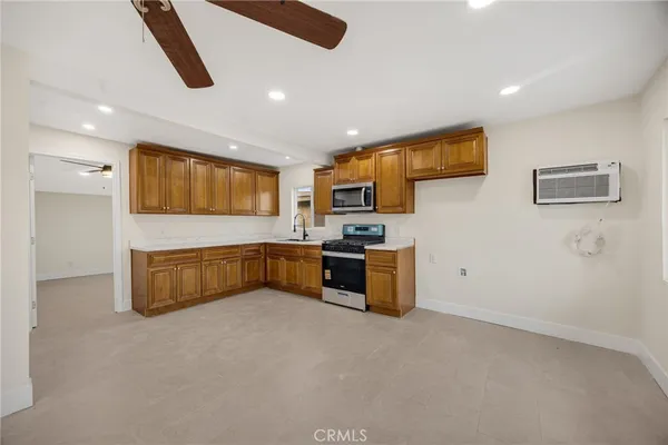 a kitchen with stainless steel appliances kitchen island granite countertop a refrigerator and a stove top oven