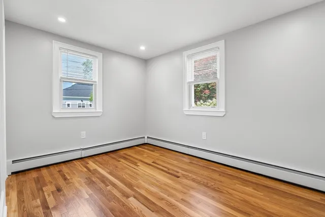 a view of a big room with wooden floor and windows