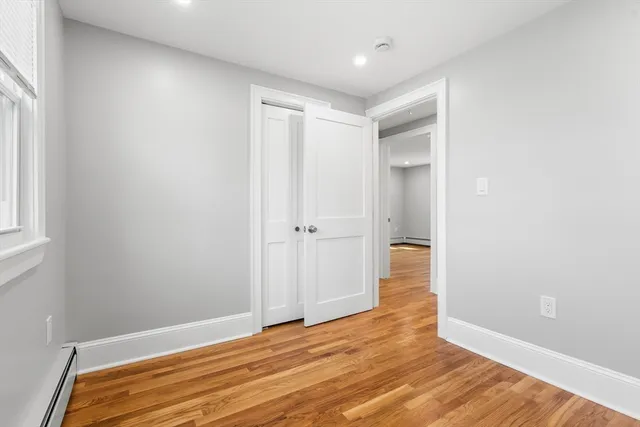 a view of empty room with wooden floor
