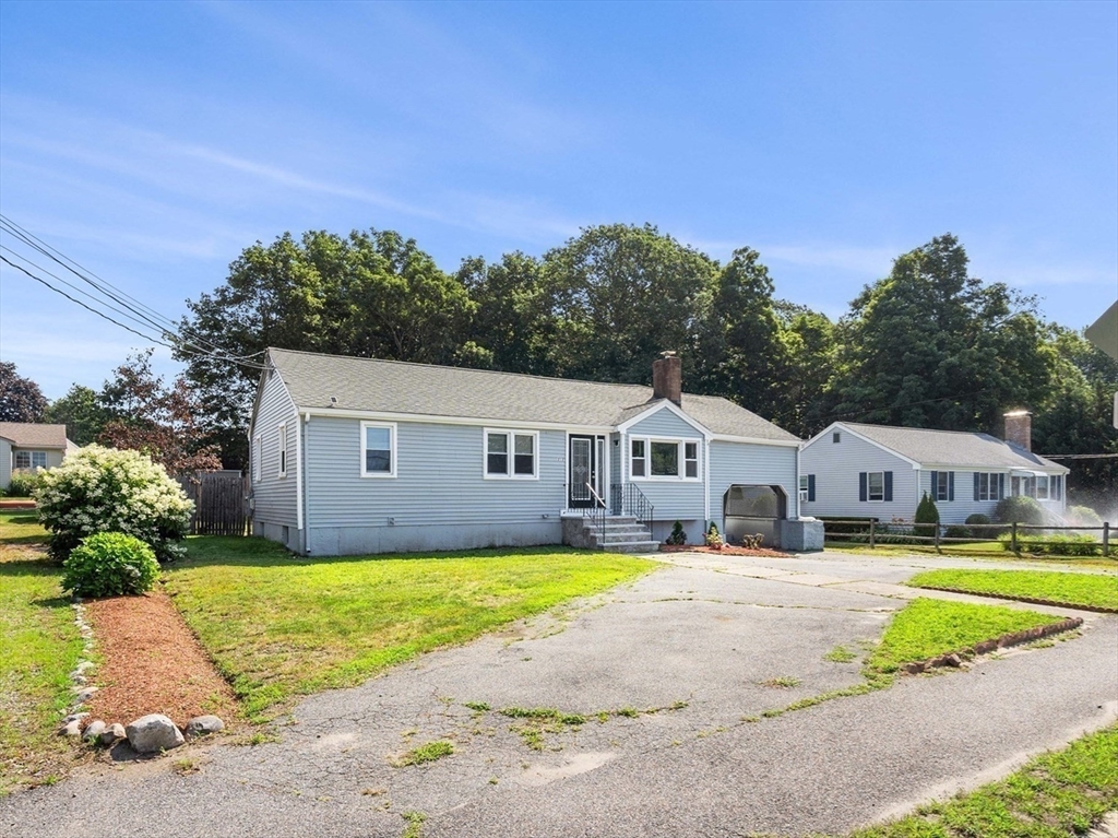 212 Cambridge Road Woburn, MA 01801 - Photo 2 of 25 a front view of a house with a yard and garage