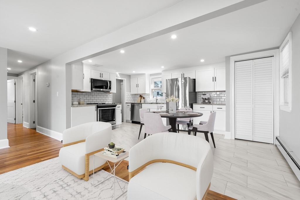 212 Cambridge Road Woburn, MA 01801 - Photo 9 of 25 a living room with furniture a dining table kitchen view and a fireplace