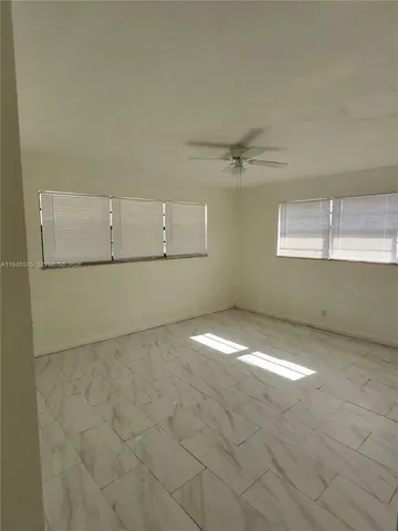 an empty room with a empty space and windows