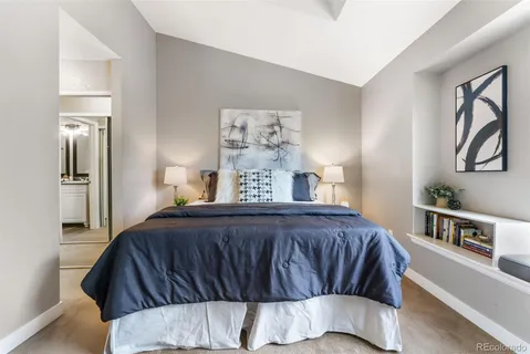 a bedroom with a bed and painting on the wall