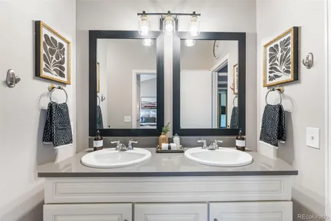 a bathroom with double sink and a mirror